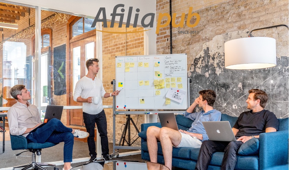 Colegas estudando estratégias de Marketing Digital com o logo de Afiliapub